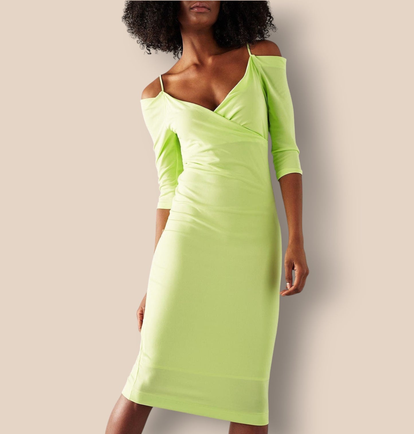 Woman wearing a bright green dress against a plain background
