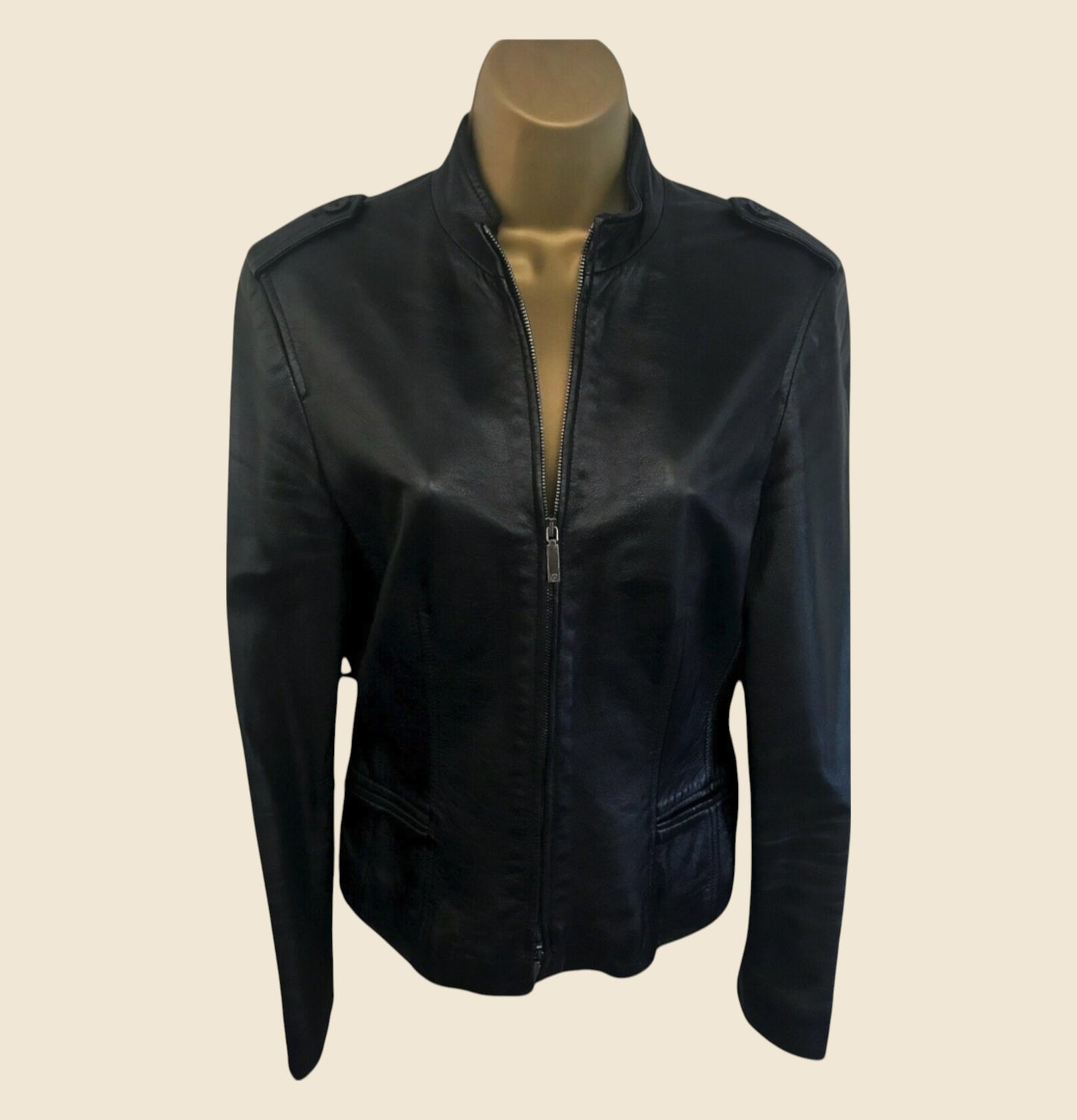 Black leather jacket on a mannequin against a beige background