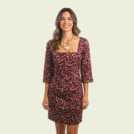 Woman wearing a patterned dress on a beige background