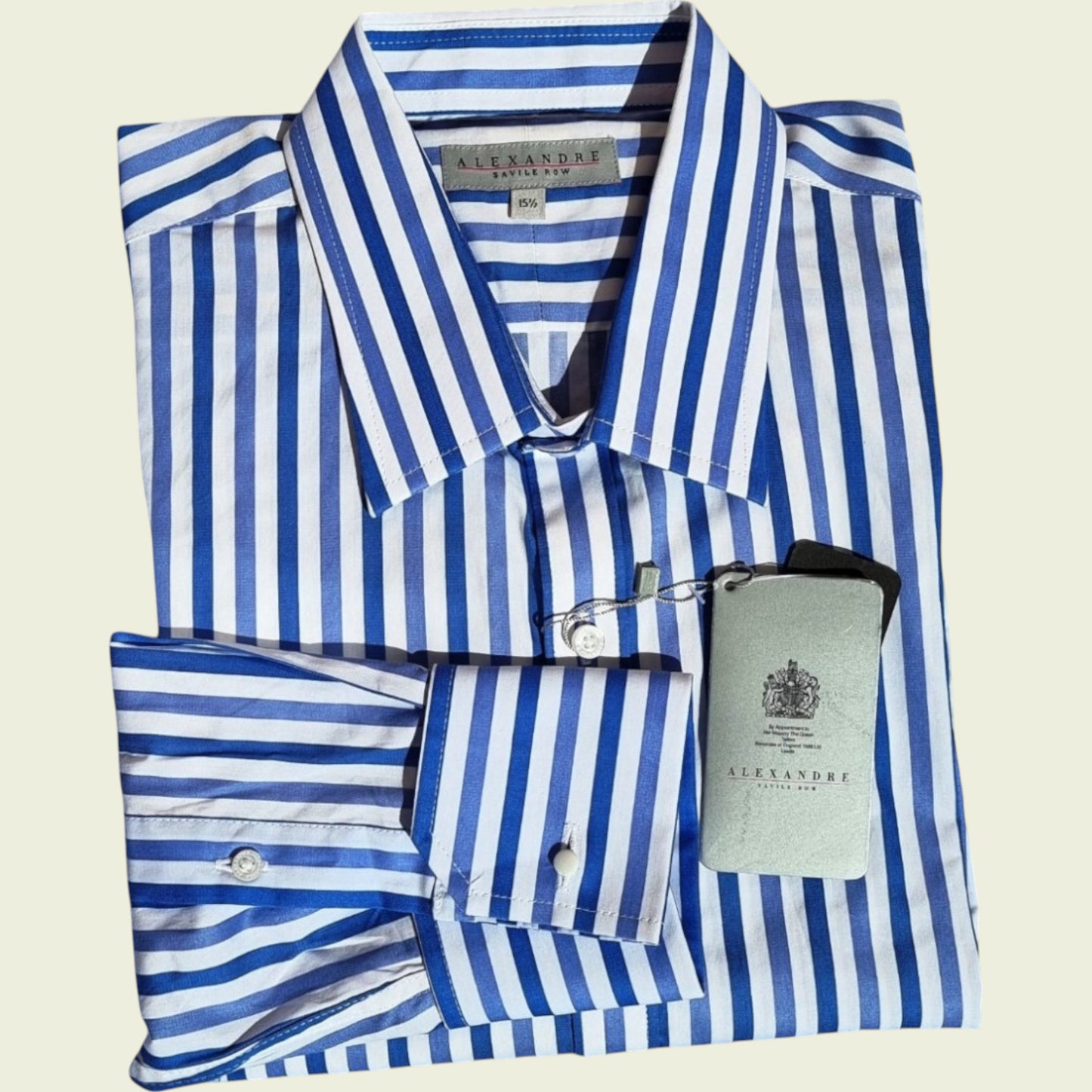 Folded blue and white striped shirt with a visible brand label on a beige background