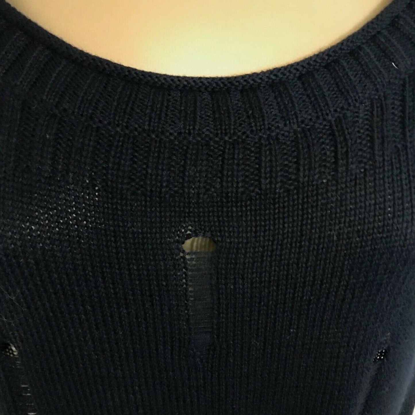 Close-up of a black knitted top with a detail