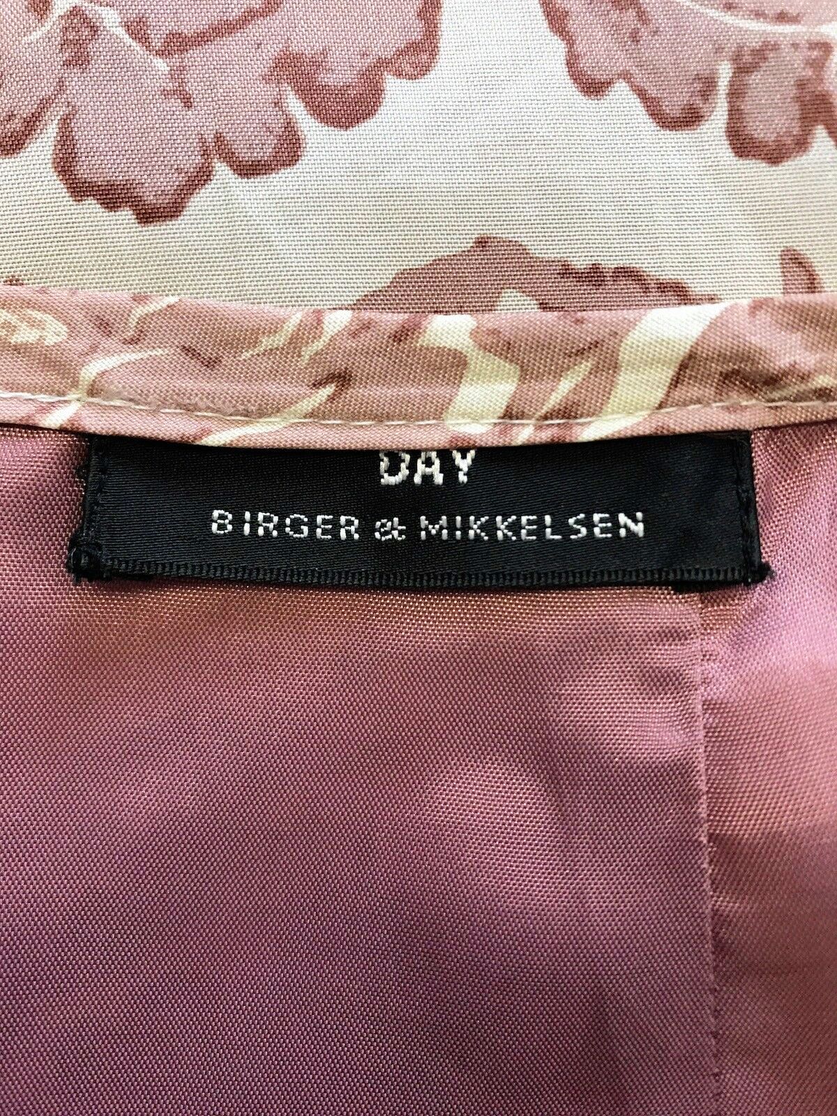 Close-up of a label on a pink floral fabric with 'Birger & Mikkelsen' branding.