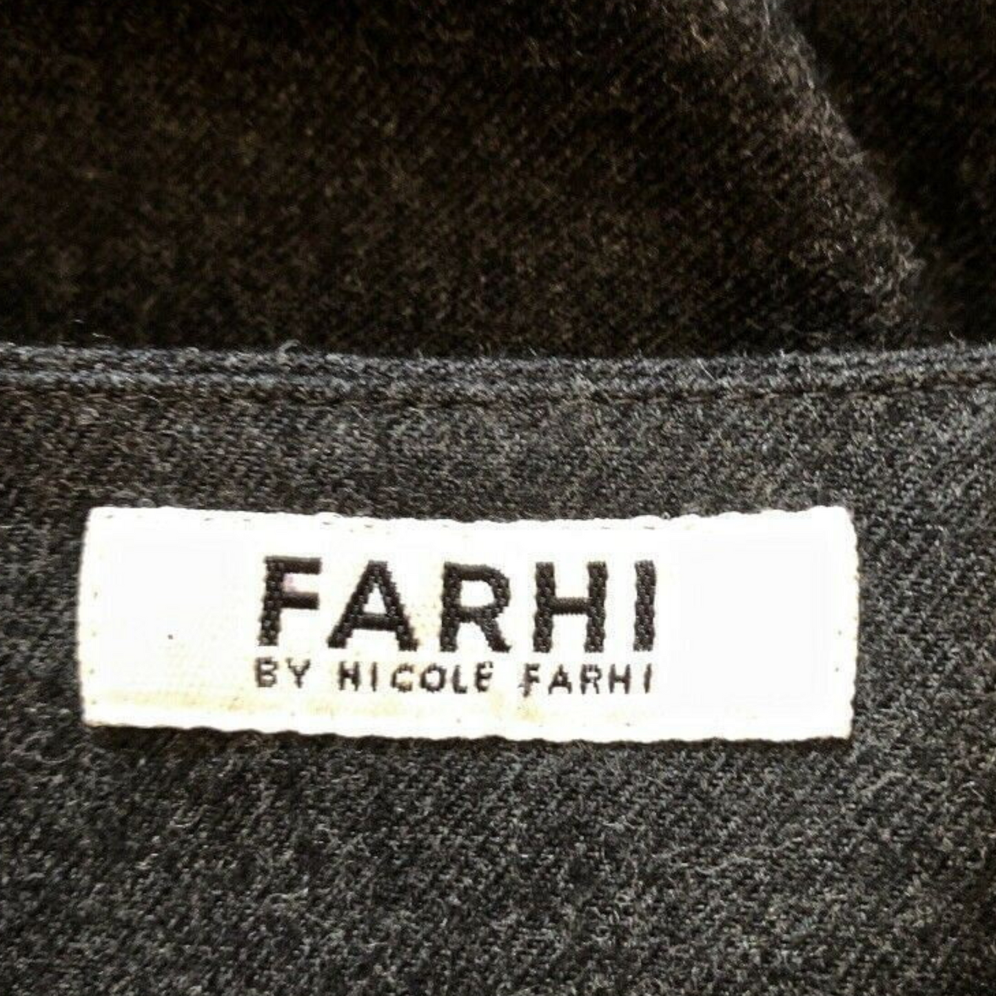 Close-up of a 'FARHI by Nicole Farhi' label on textured fabric.