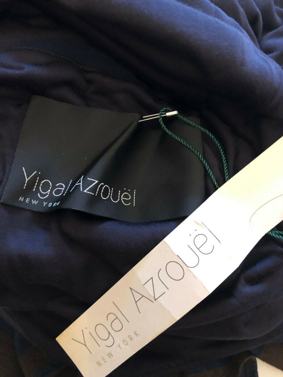 Yigal Azrouel label on a garment with a dark background