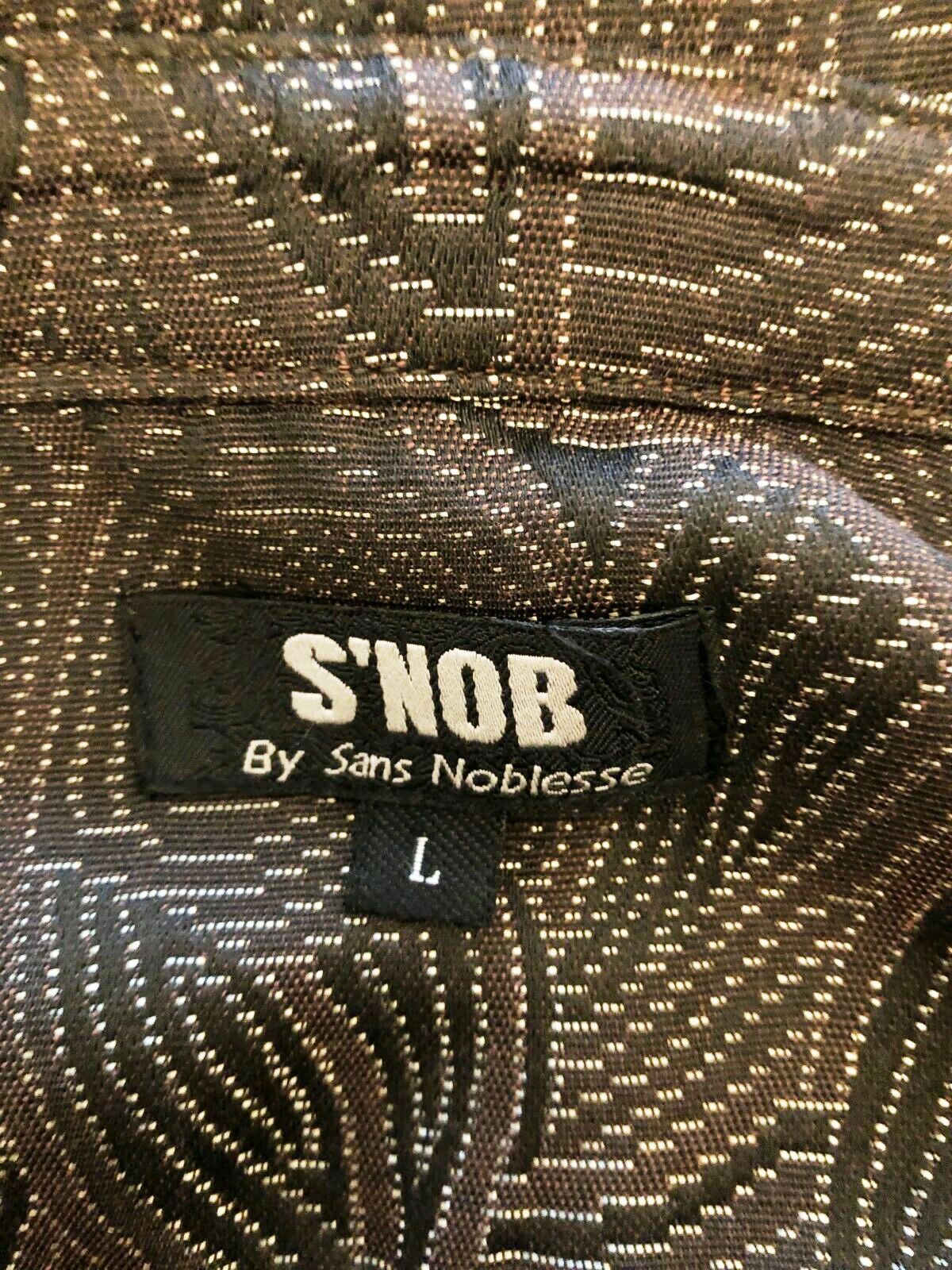 Close-up of a 'S'NOB by Sans Noblesse' label on a patterned fabric.