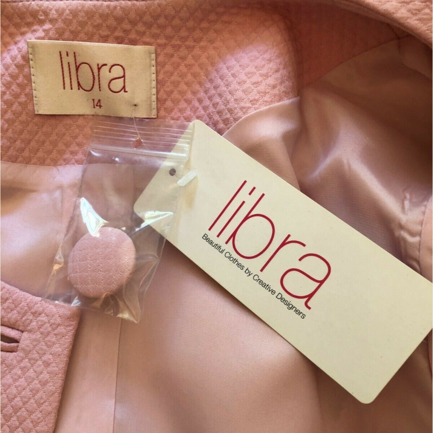 Pink garment with 'libra' label on a textured pink background