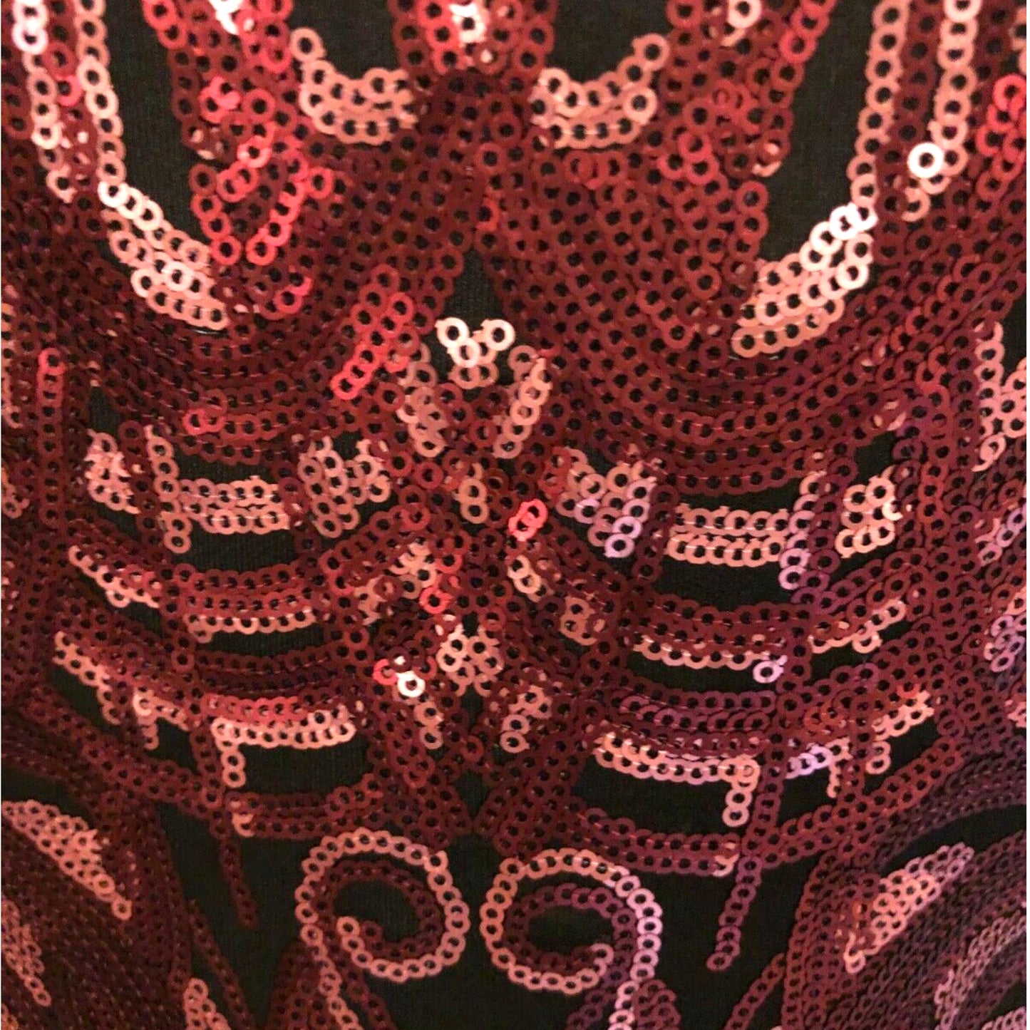 Close-up of pink sequin fabric on a black background