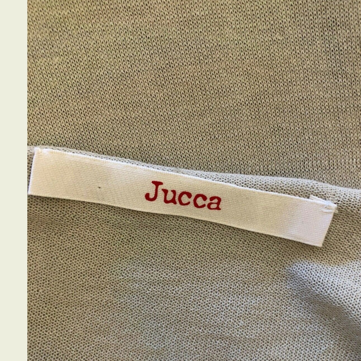Label with 'Jucca' text on a textured fabric background
