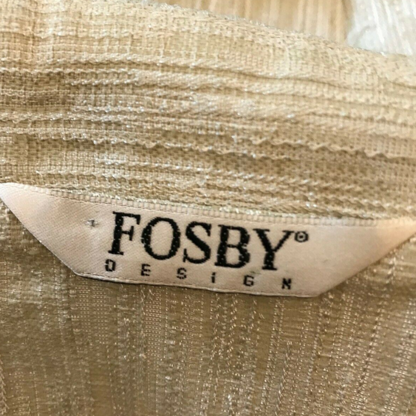 Close-up of a gold fabric with 'Fosby Design' label
