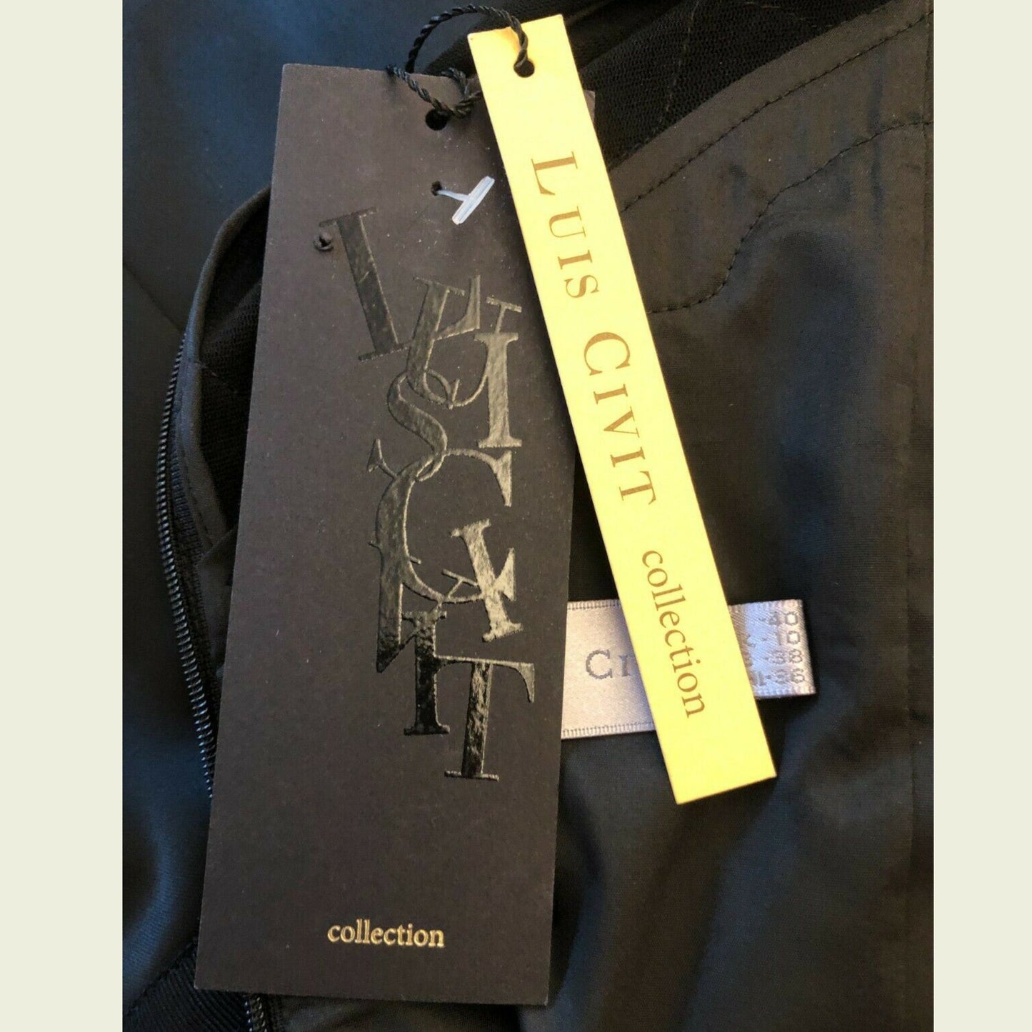 Black and yellow tags on a dark fabric background, featuring 'Luis Civit' branding.