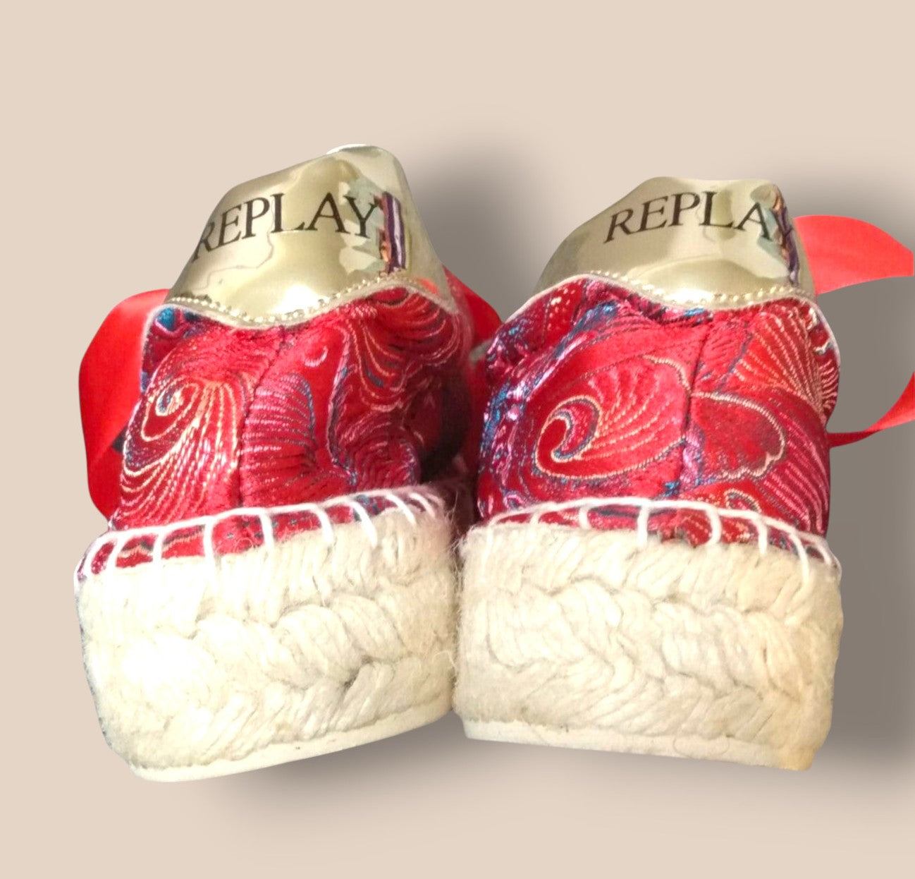 Red boxing gloves with white accents and 'REPLAY' branding on a beige background