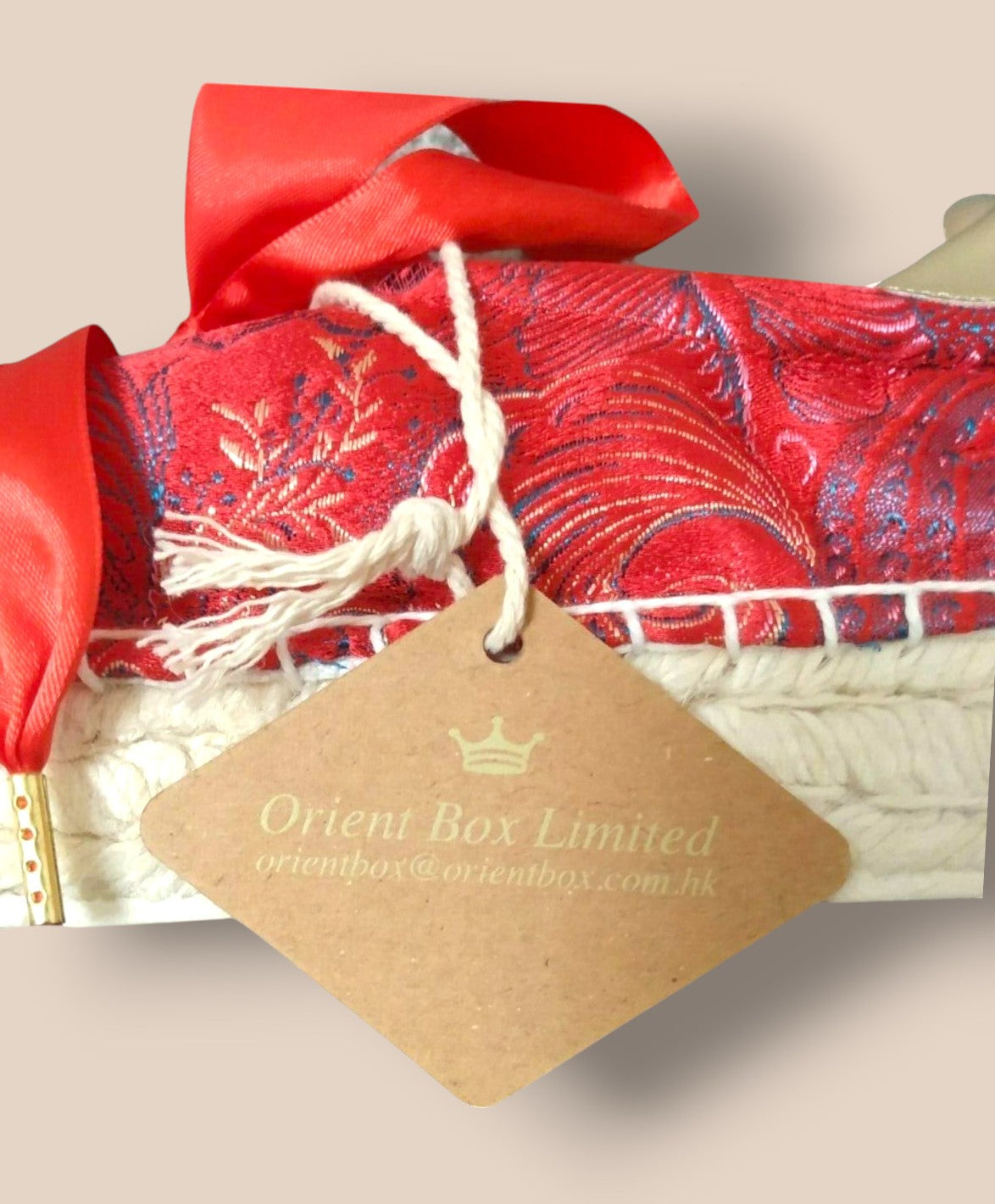 Red decorative item with a 'Orient Box Limited' tag on a beige background