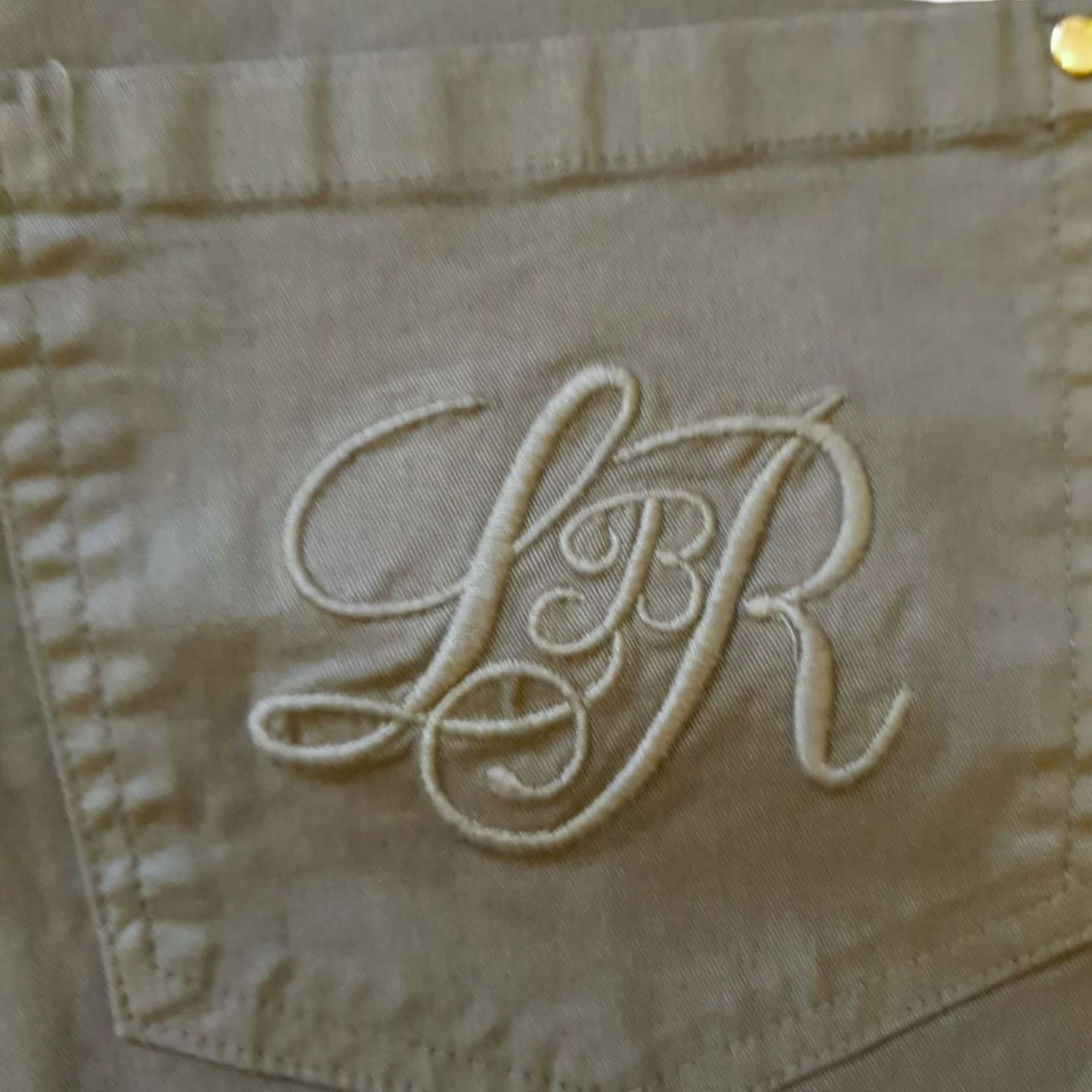 Embroidered pocket with Libra moniker on khaki jeans