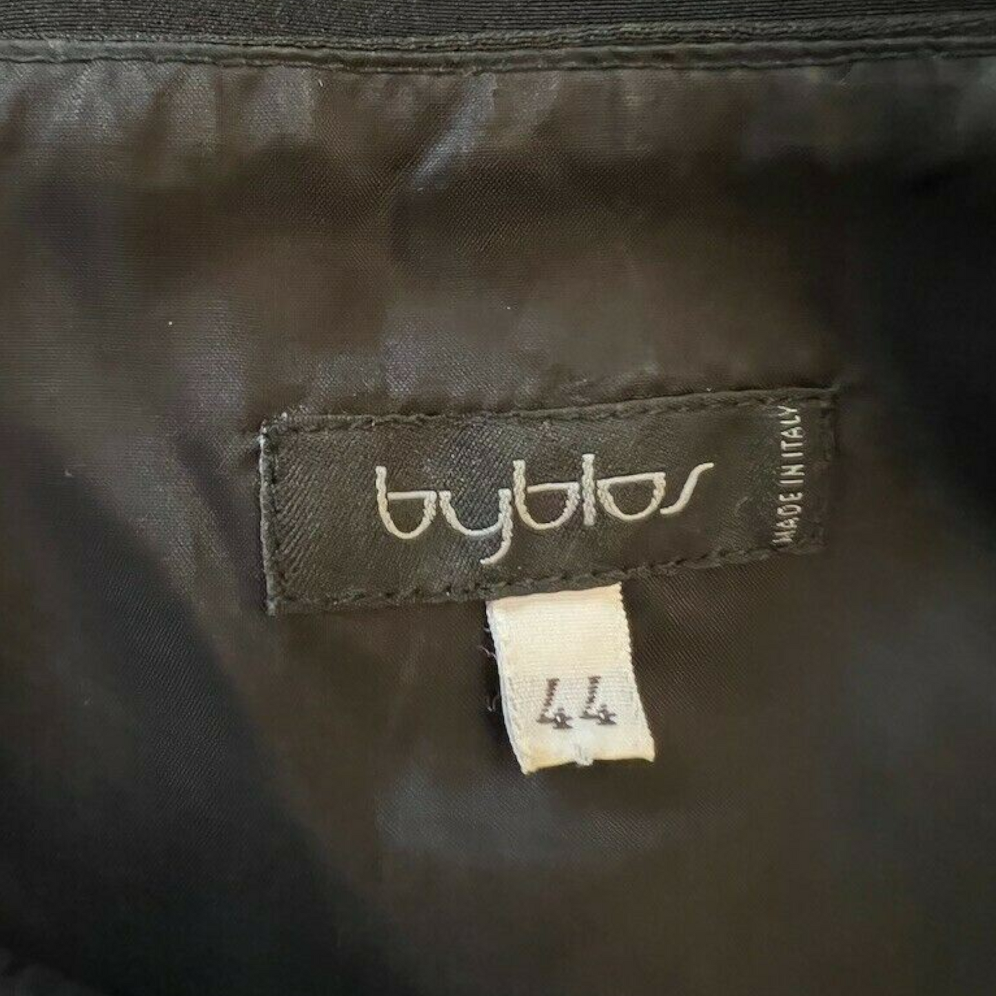 Close-up of a Byblos label on dark fabric