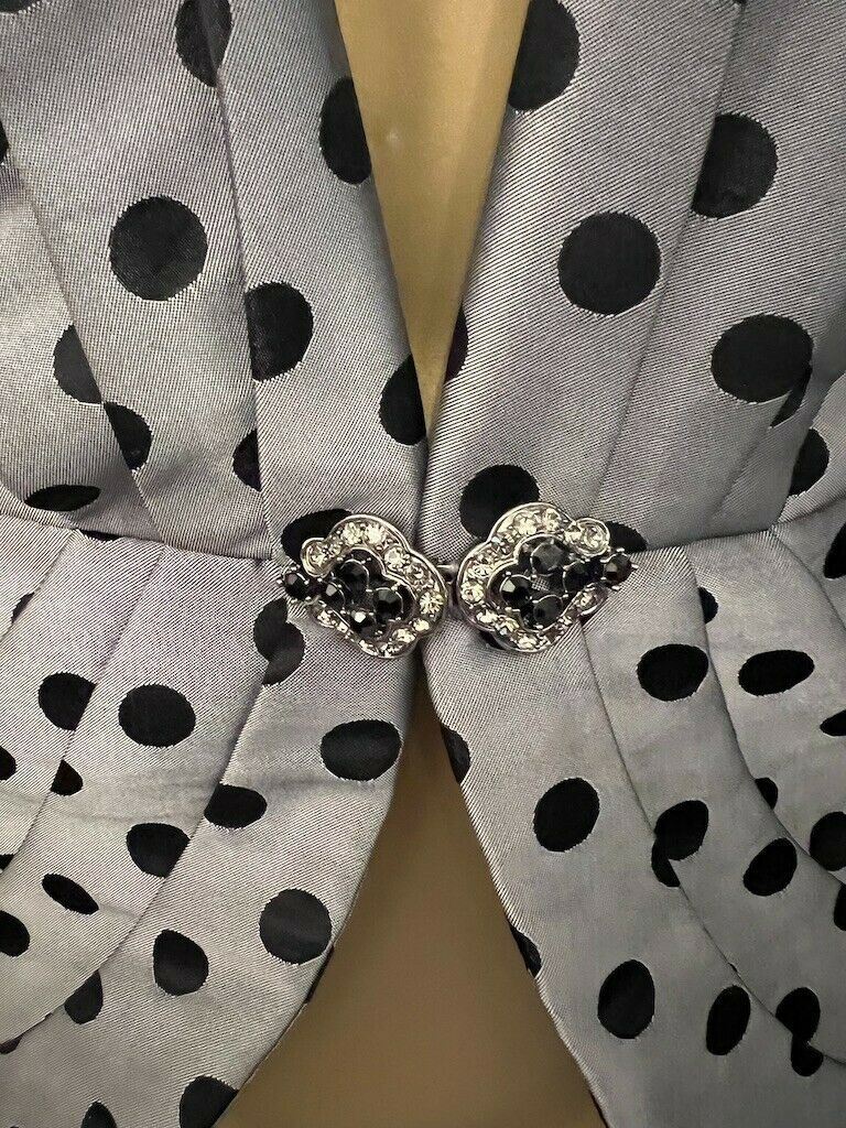 Gray fabric with black polka dots and decorative buttons on a beige background