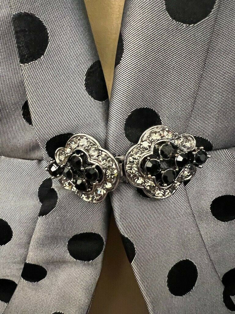 Silver buckle with black stones on a polka dot fabric background
