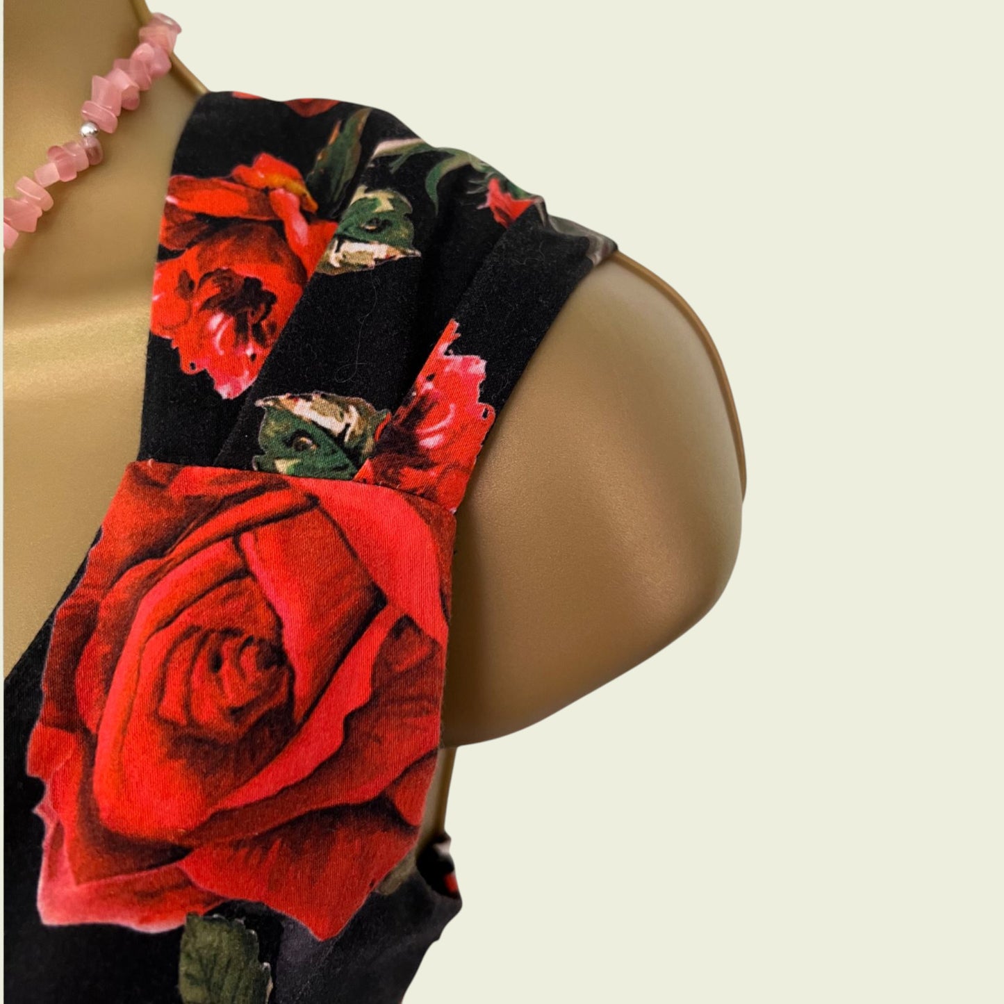 Dress with red floral patterns on a mannequin.