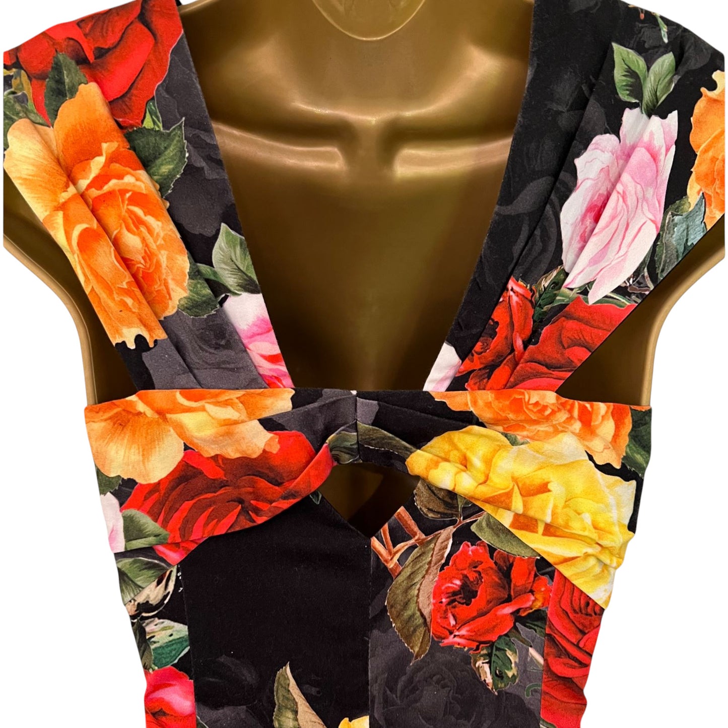 Mannequin wearing a floral-patterned garment with vibrant colors on a white background