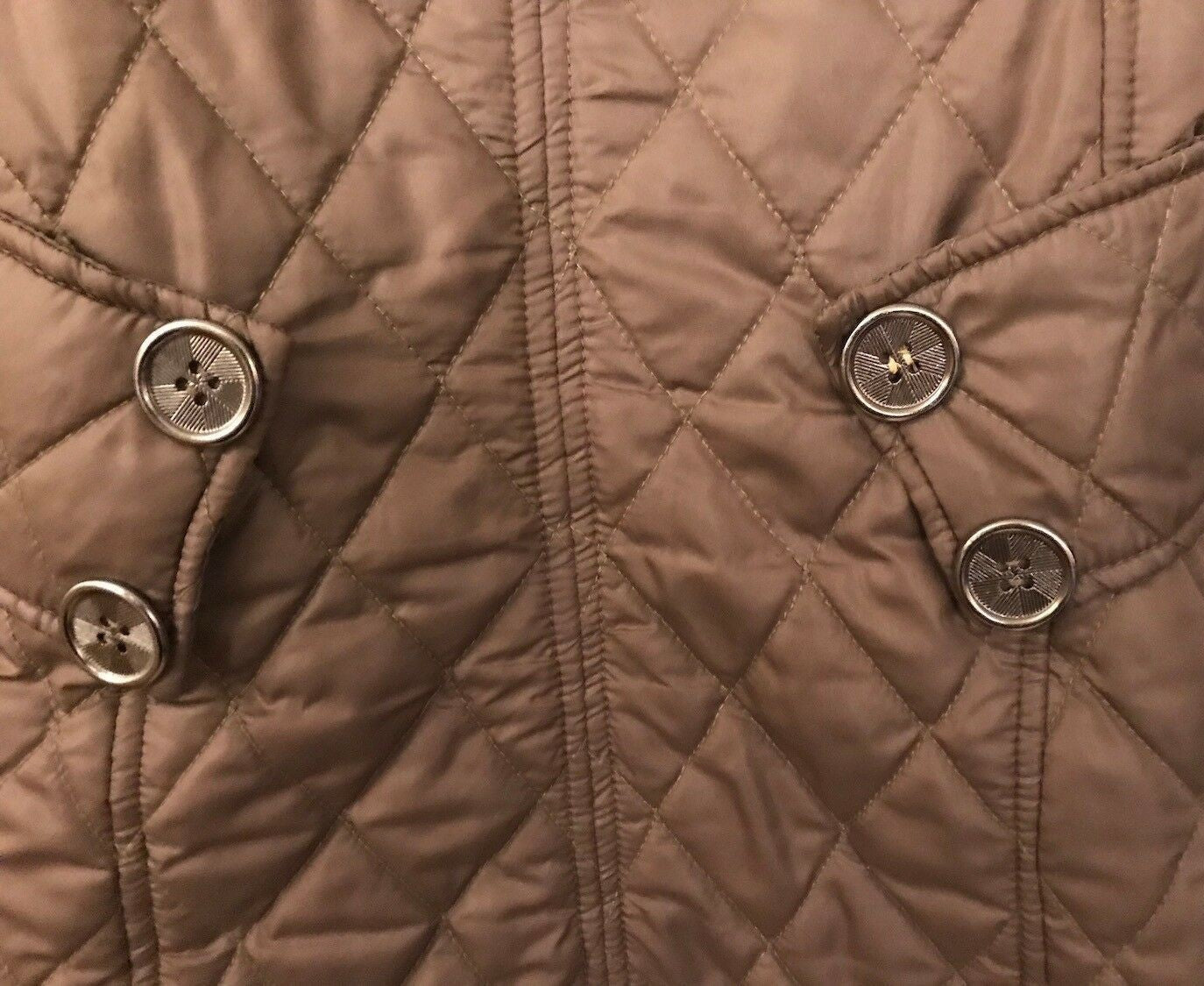 Close-up of a quilted brown jacket with button details