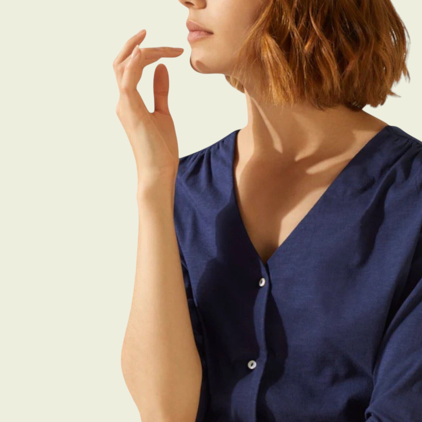 Woman wearing a navy blue cardigan with a plain background