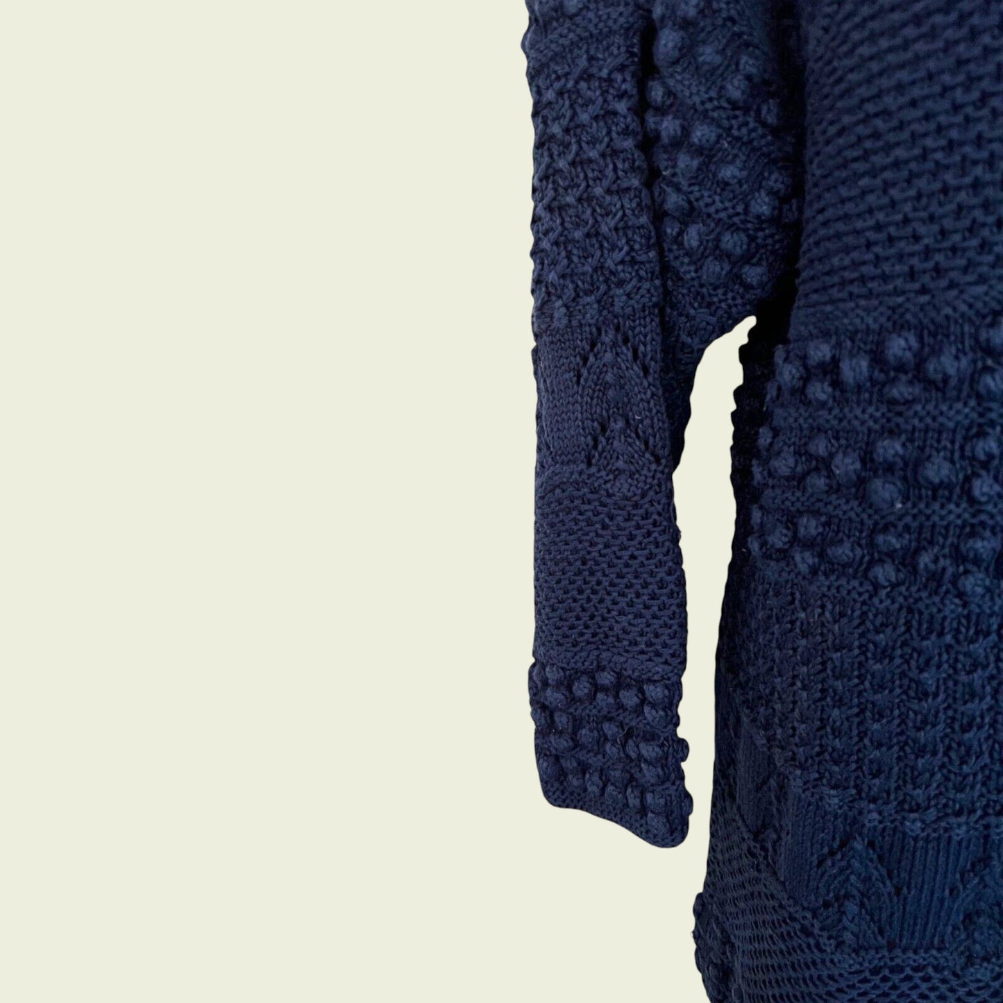 Close-up of a navy blue textured garment on a beige background
