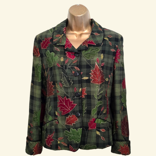 A women's long-sleeve plaid jacket with a red and green maple leaf pattern, displayed on a mannequin torso against a light beige background.
