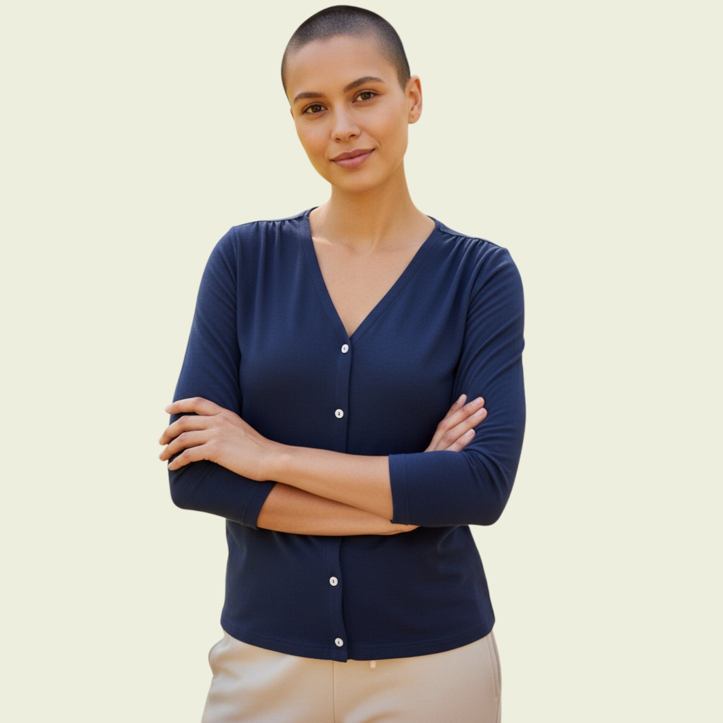 woman wearing a navy blue cardigan on a beige background