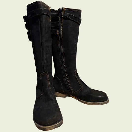 Pair of black boots on a beige background