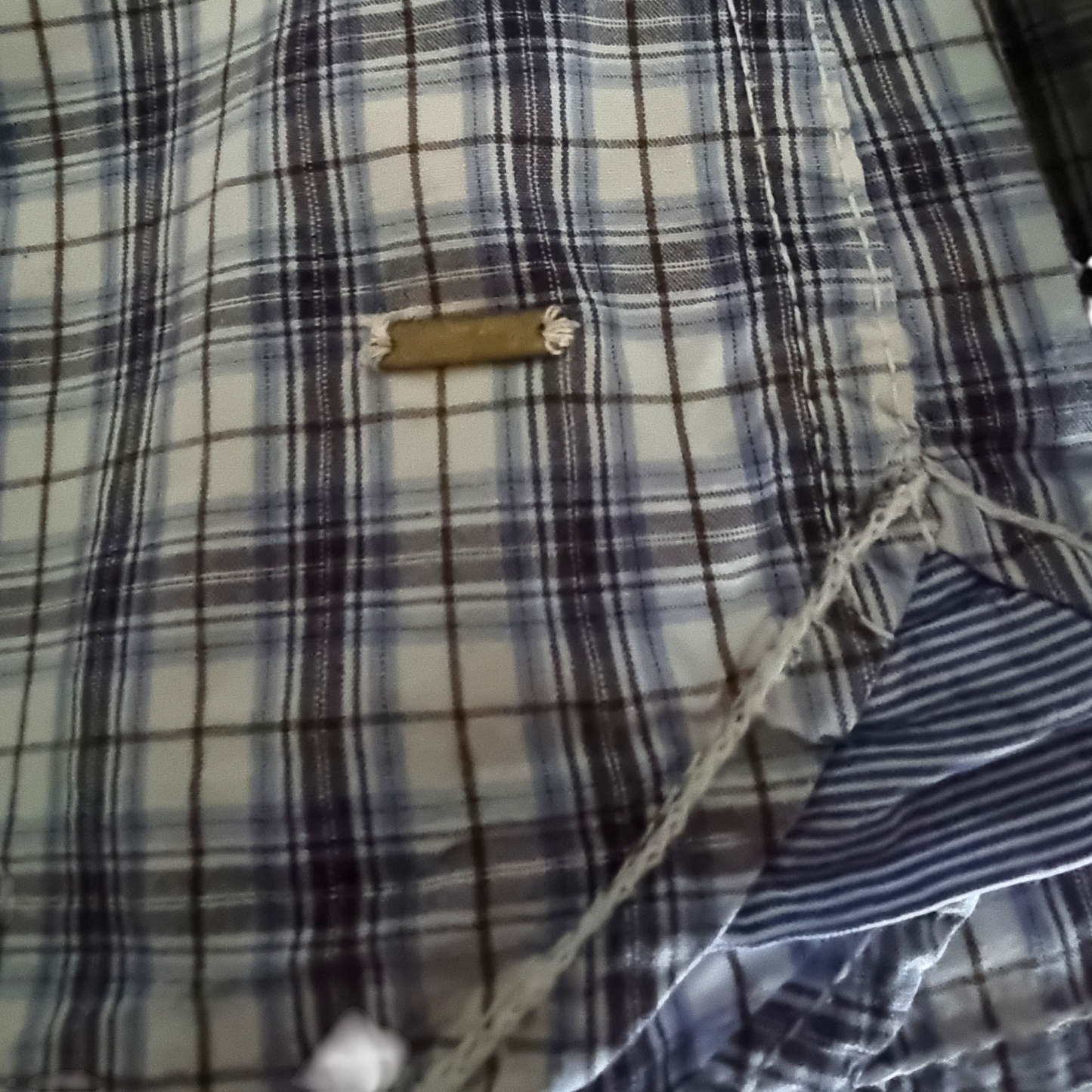 Close-up of a plaid shirt with a brand label.