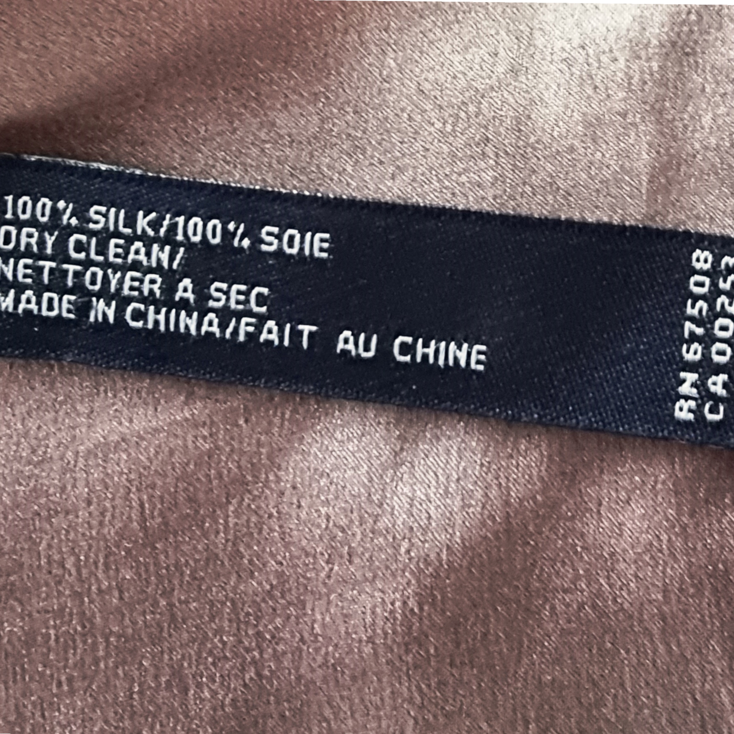Text label on silk fabric indicating care instructions and origin.