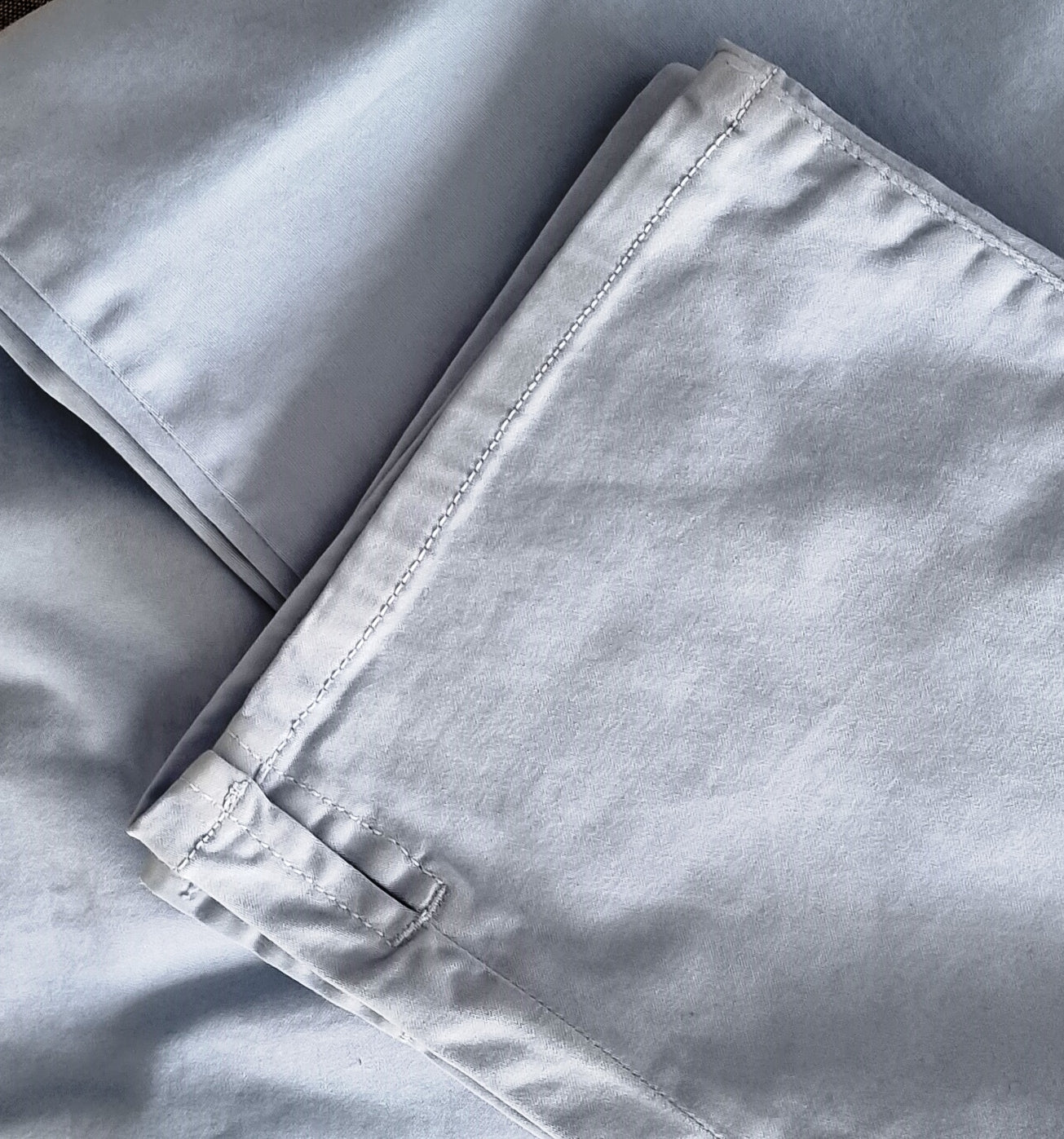 Close-up of light gray pants with a focus on hem slit detail.