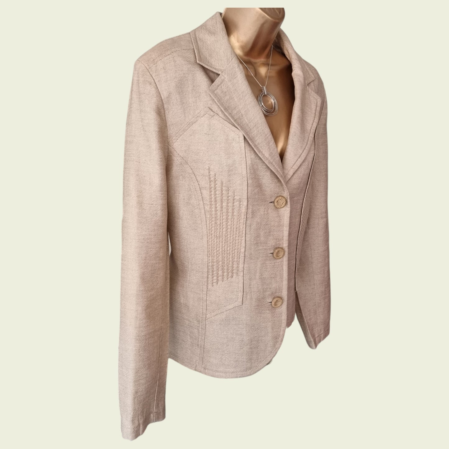 Beige blazer on a mannequin against a beige background