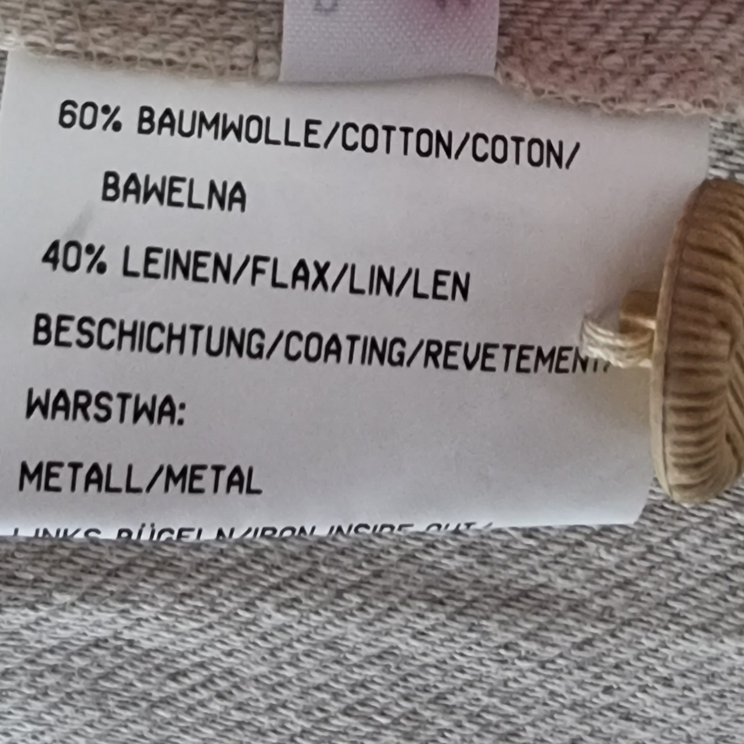 Fabric label with material composition details on a textured fabric background