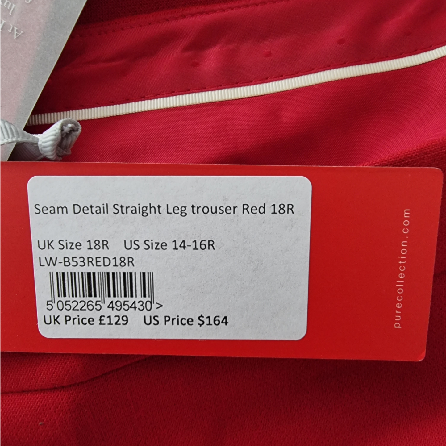 Red garment with a label detailing size, price, and barcode on a red background