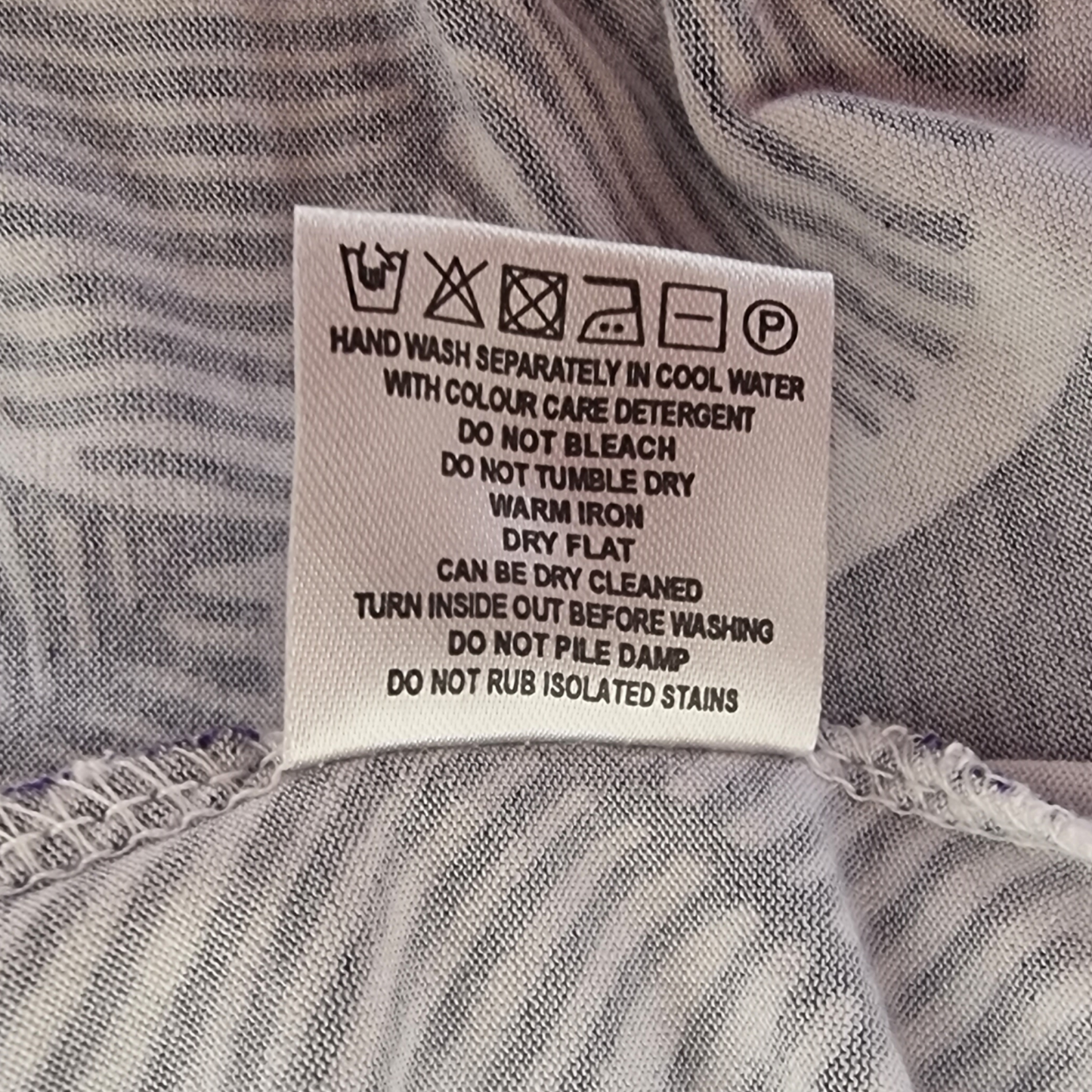 Clothing label showing laundry details on blue and white background