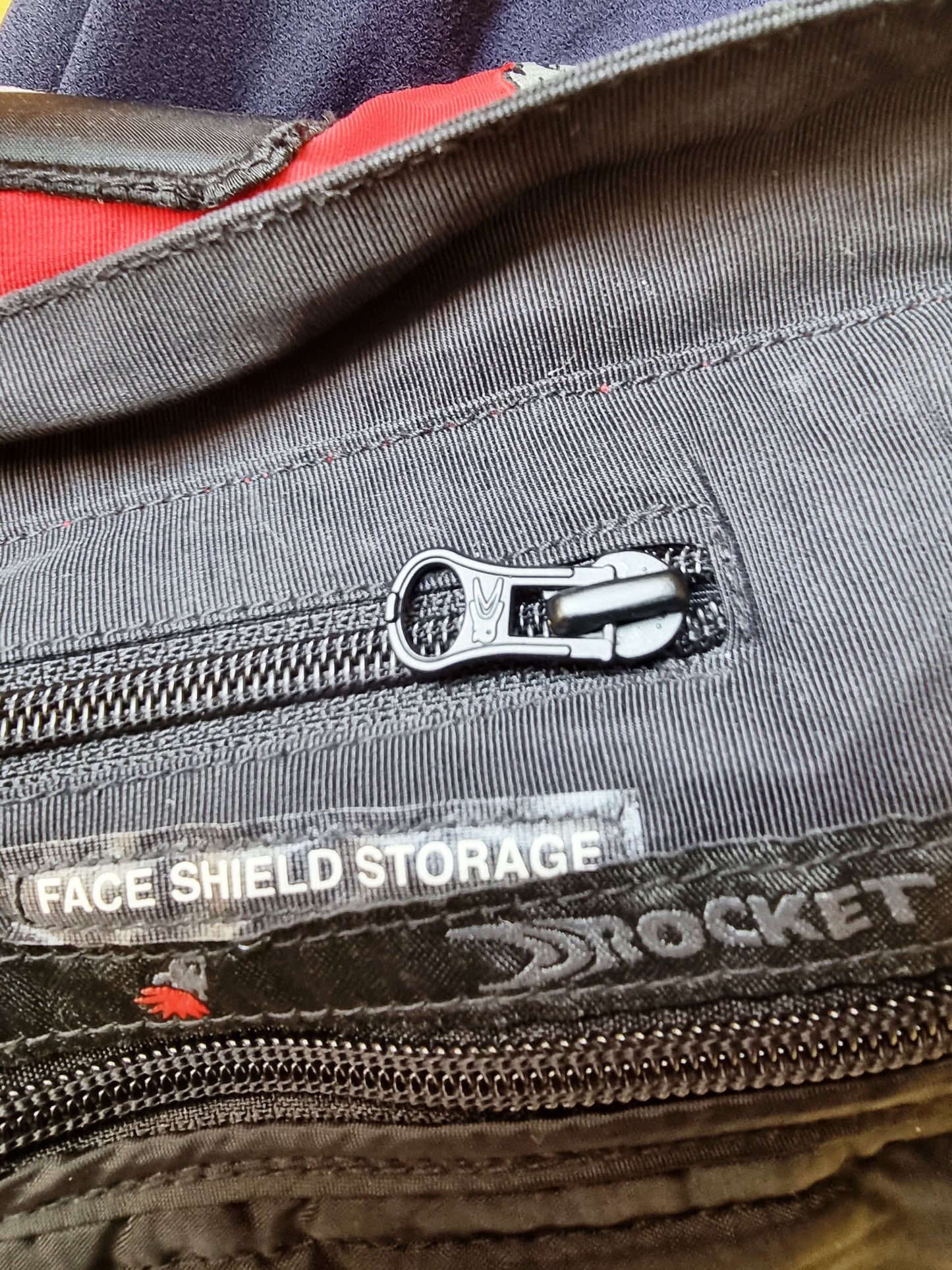 Close-up of a zipper on a jacket with 'Rocket' branding and text.