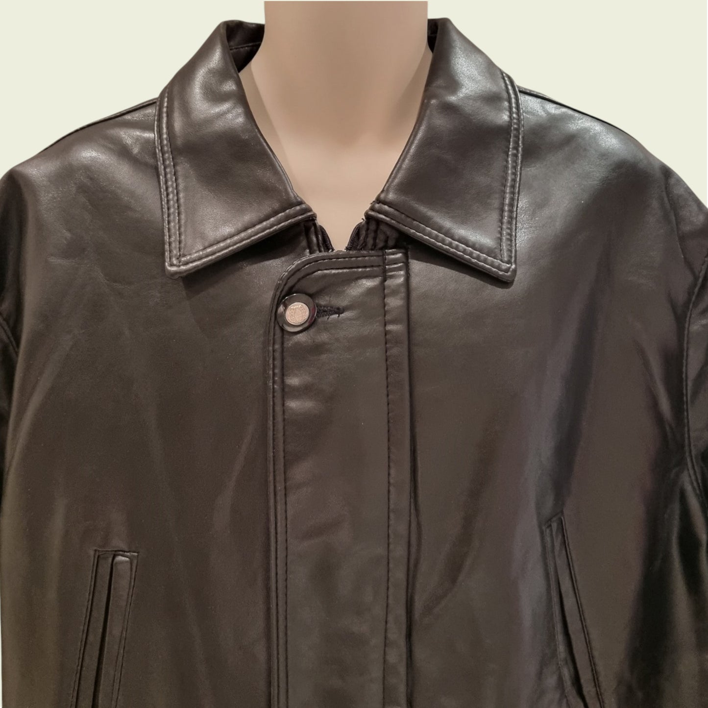 Black leather jacket on a mannequin with a plain background