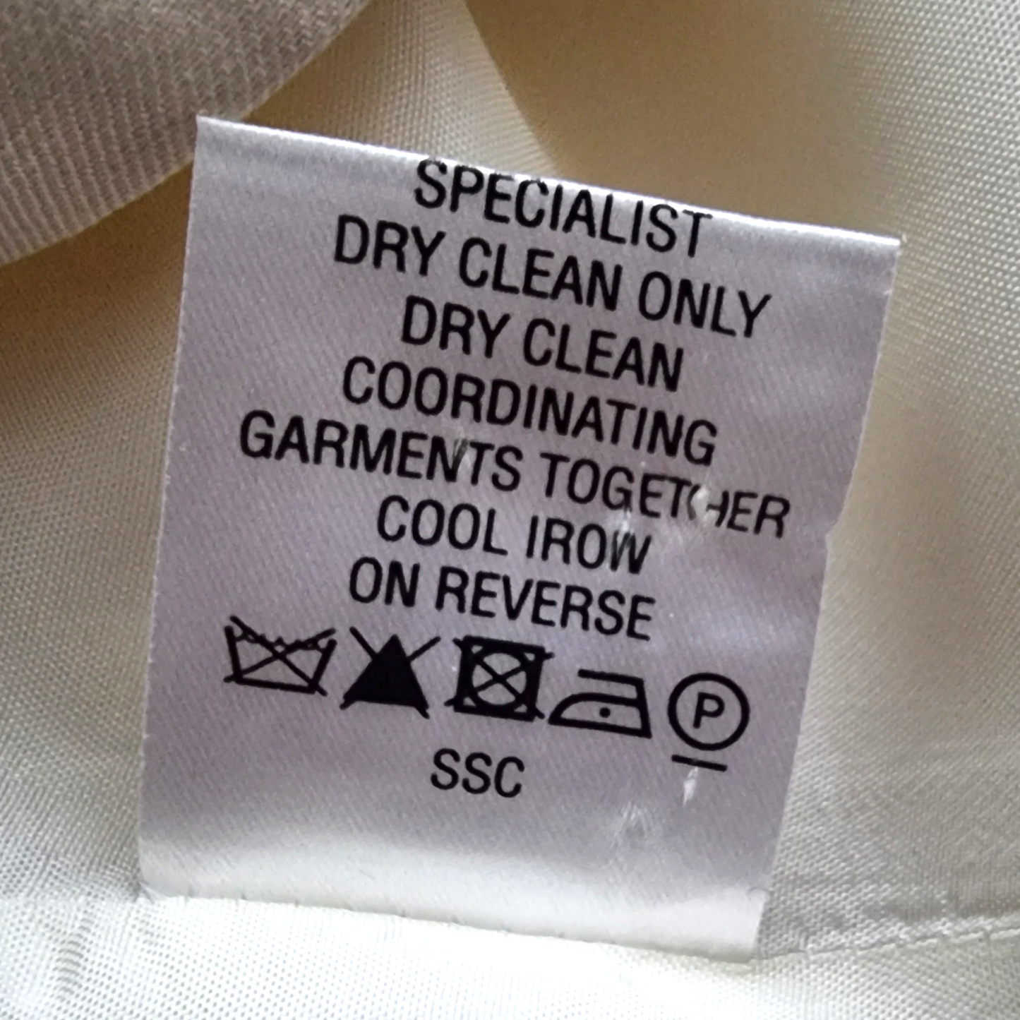 Dress label with care details on cream background