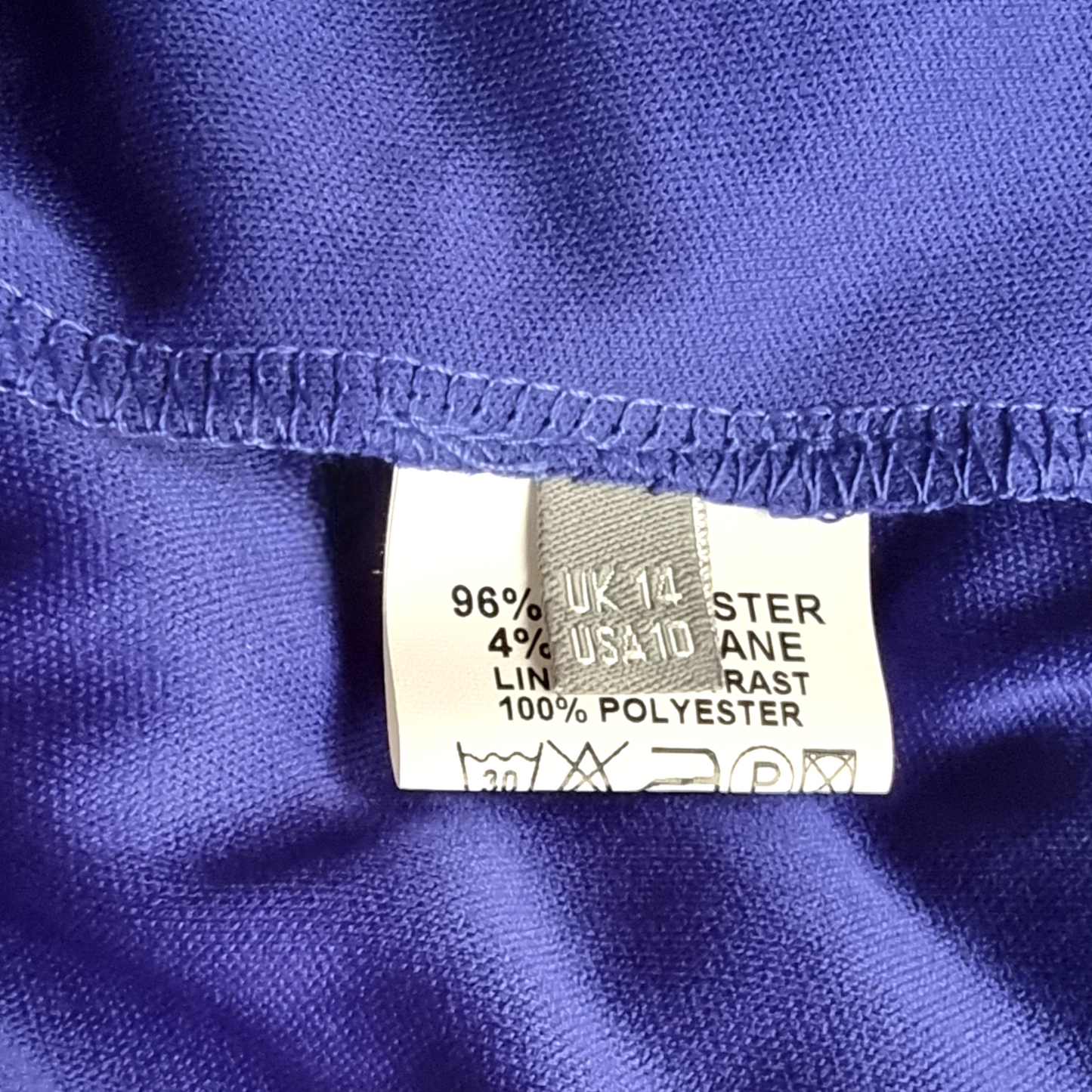 Fabric label on a blue garment with material information.