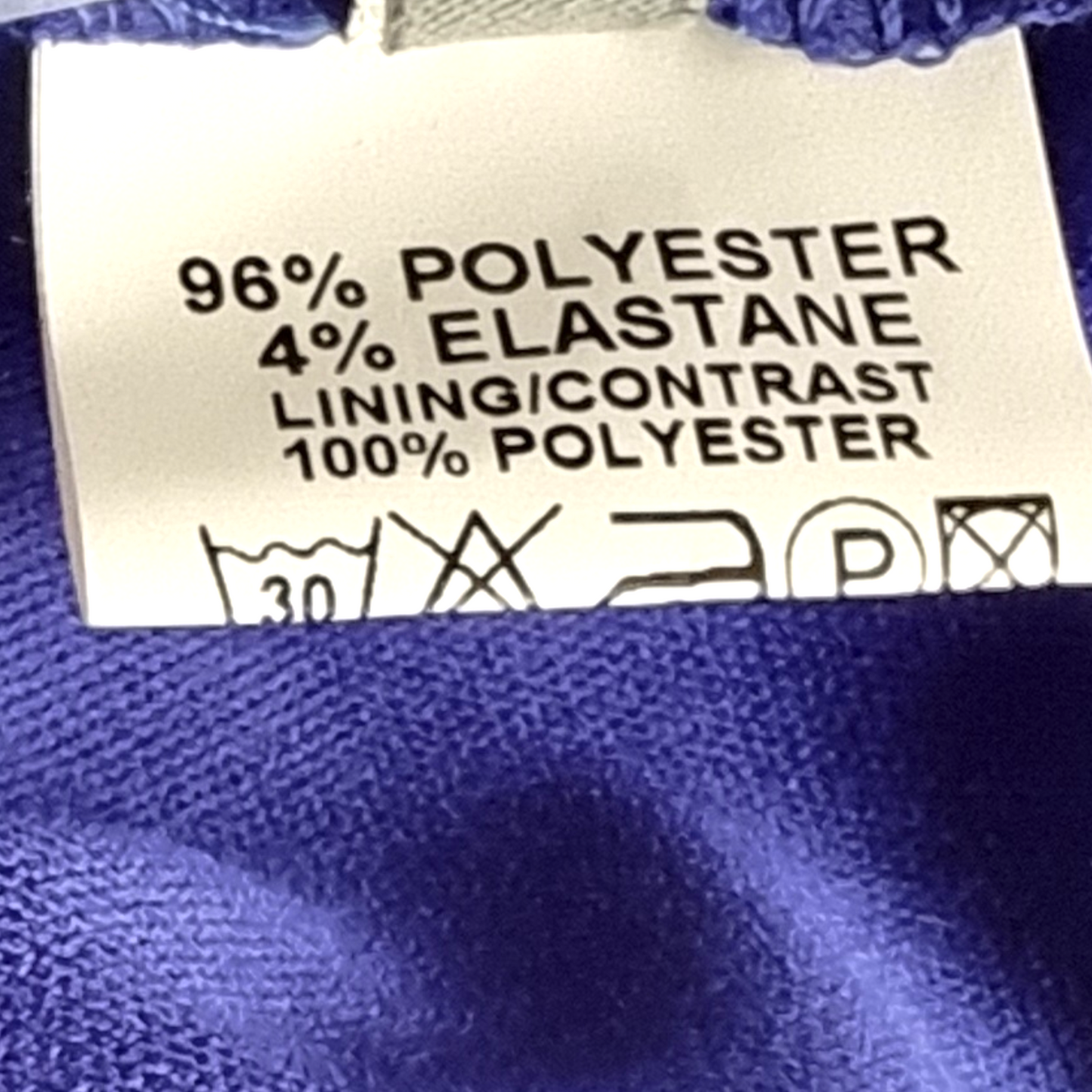 Clothing label with fabric composition details on a blue fabric background