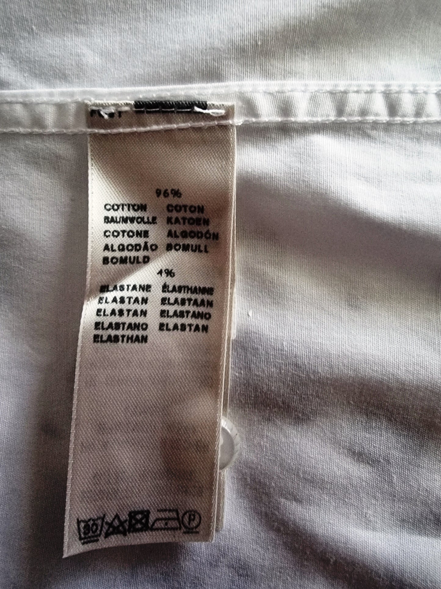Clothing label with fabric composition details on a white fabric background