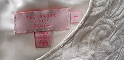 Close-up of a label on a white garment with floral patterns