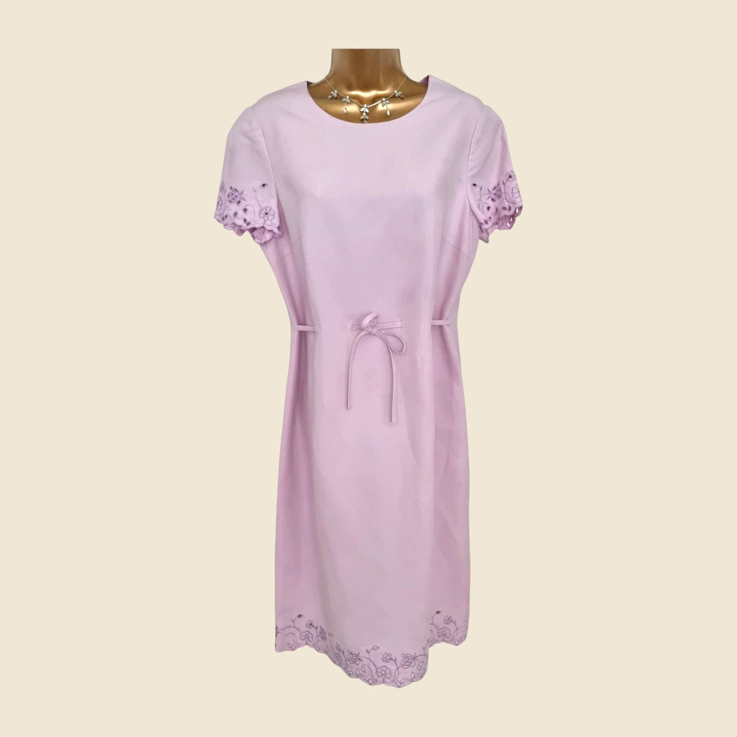 Light purple dress with lace details on a beige background