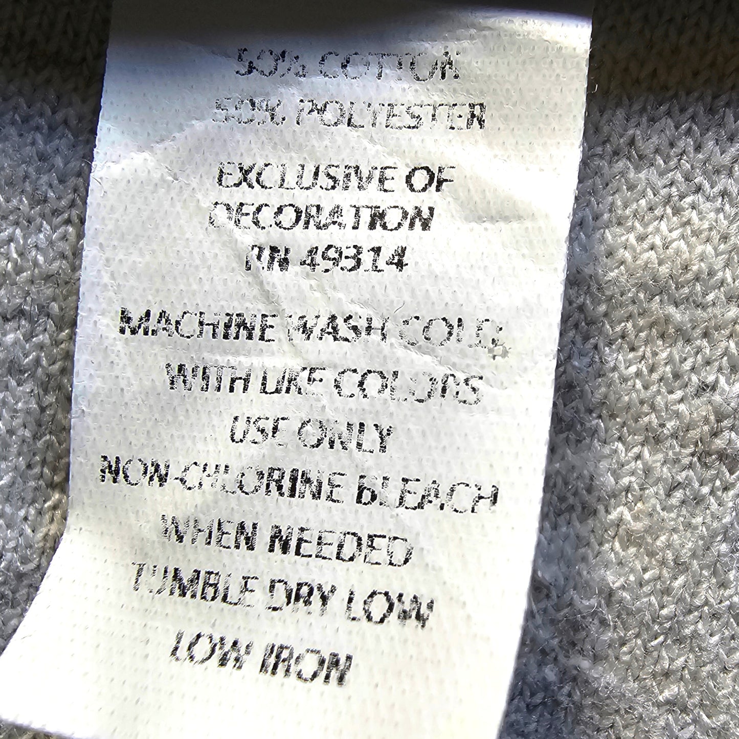 Fabric tag with washing instructions on a textured fabric background
