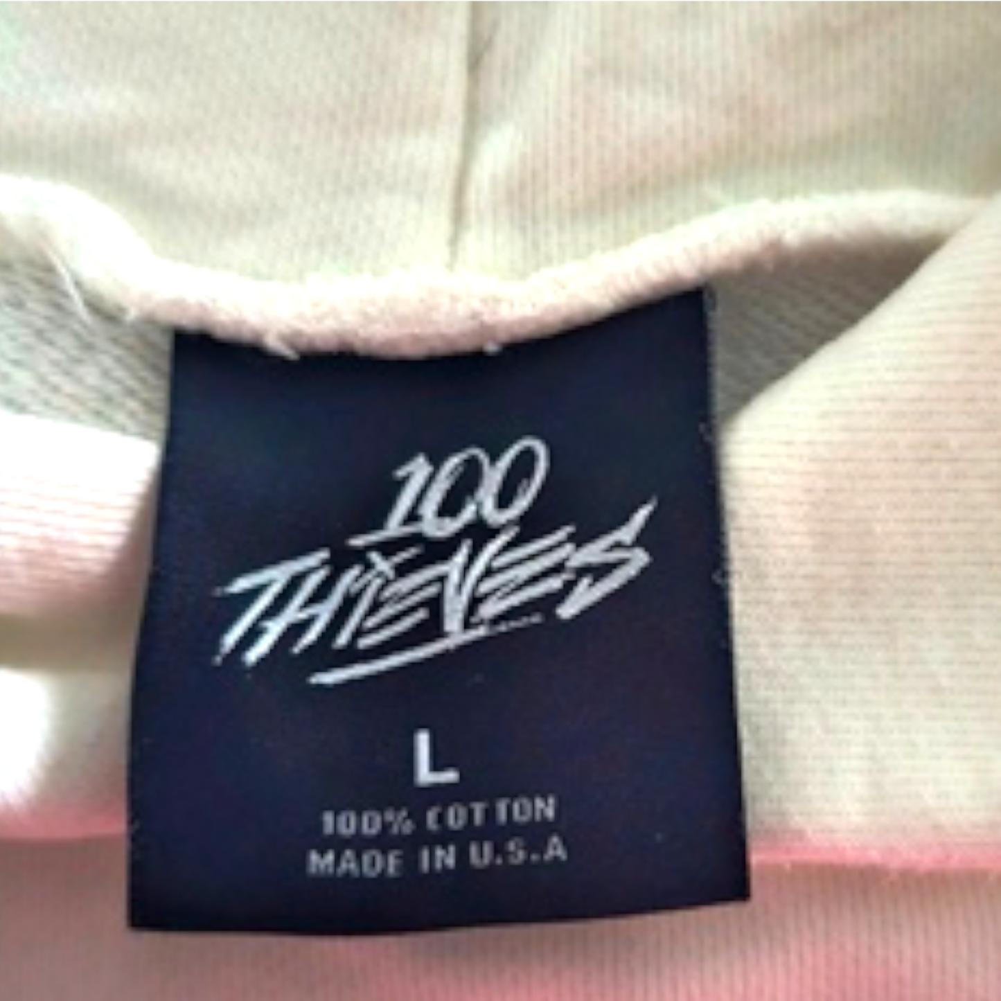 Label with '100 Thieves' branding on a garment
