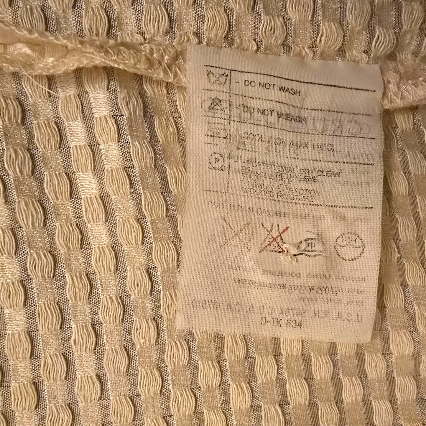 Close-up of a fabric label on textured beige fabric