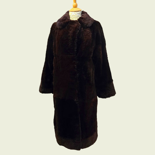 Brown fur coat on a mannequin against a plain background