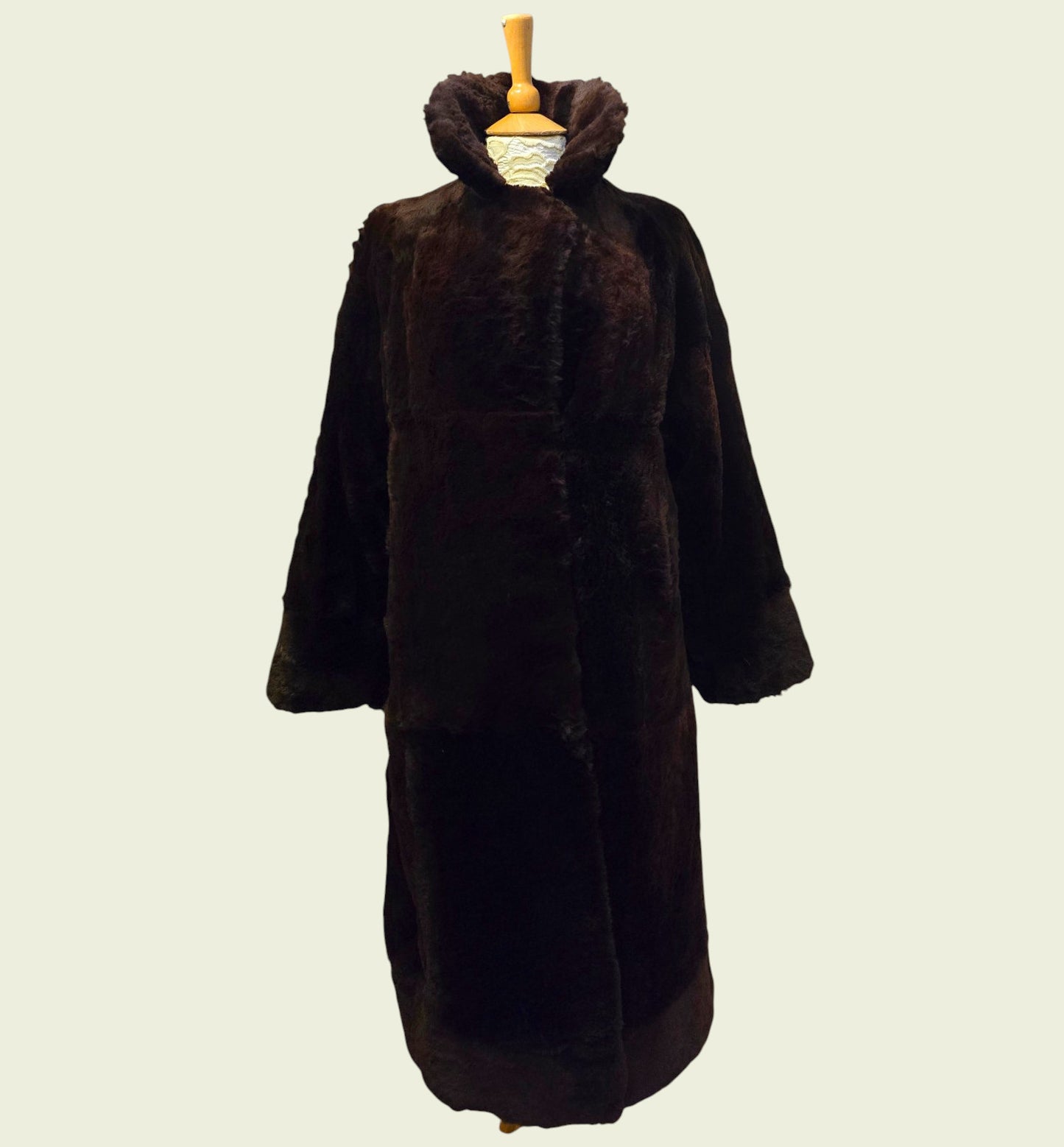 Brown fur coat on a mannequin against a plain background