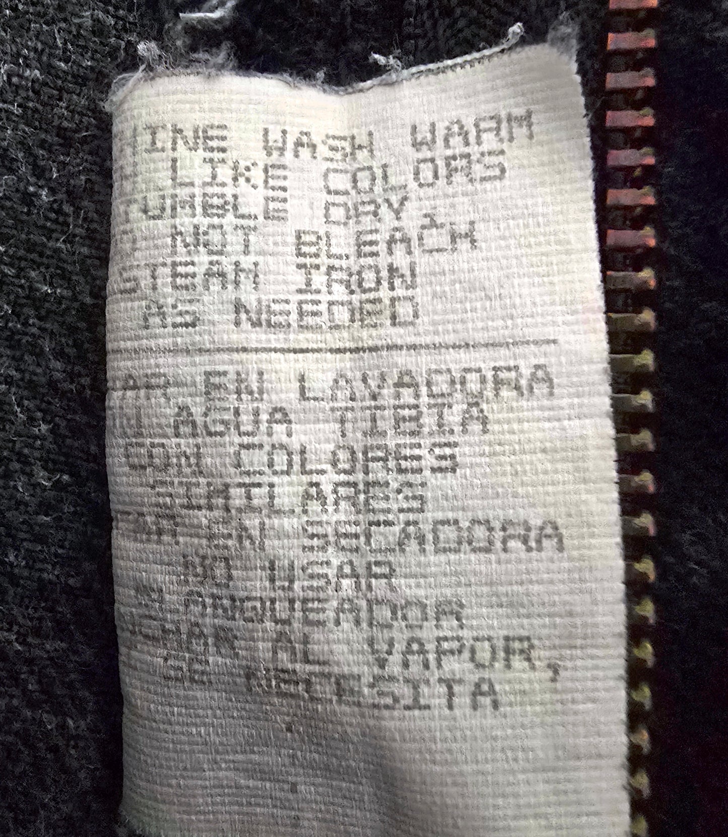 Fabric tag with washing instructions on a dark background