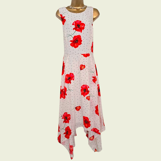 Mannequin wearing a white dress with black polka dots and red poppies on beige background